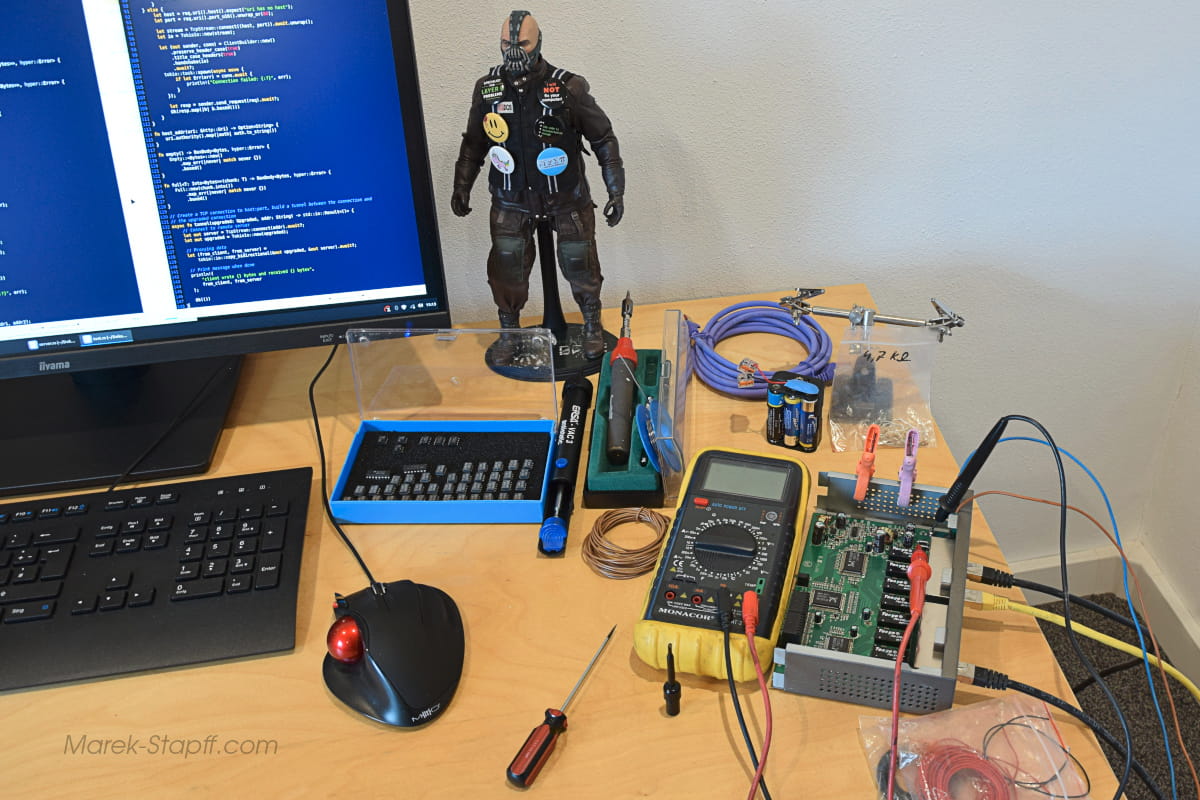 Geöffneter Netzwerkswitch mit freiliegender Platine, Messgerät und Lötkolben